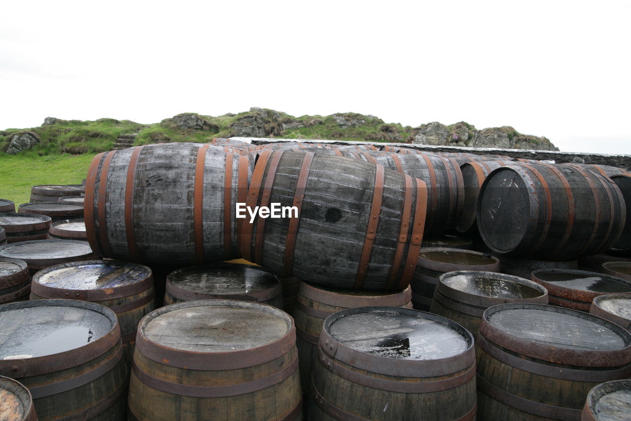 Barrels arranged against clear sky at factory