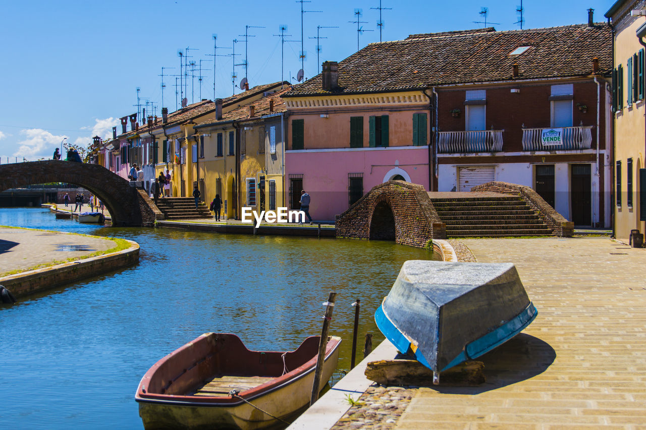 Boats moored on shore against sky