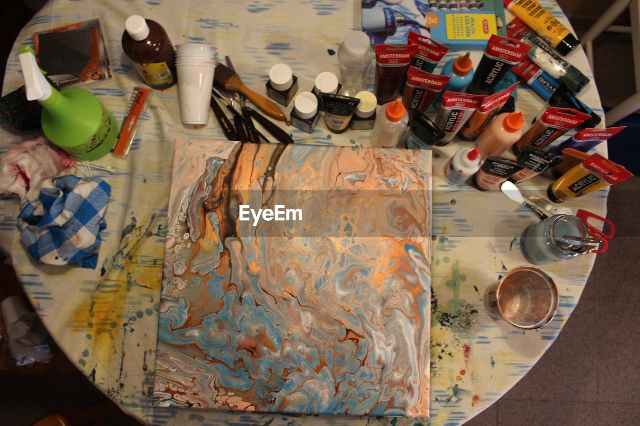 HIGH ANGLE VIEW OF PAINTBRUSHES AND TABLE ON FLOOR