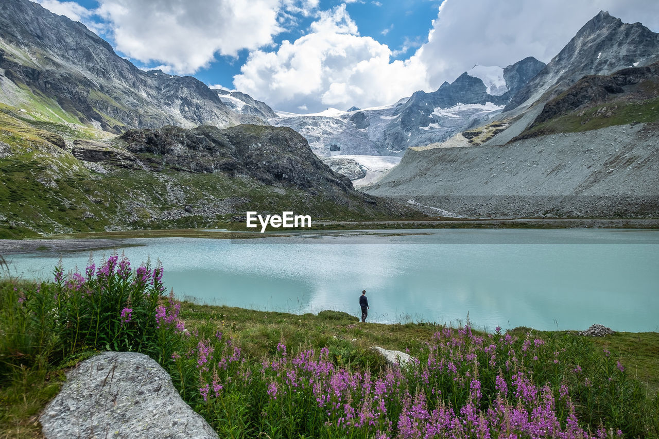 Scenic view of lake by mountains against sky