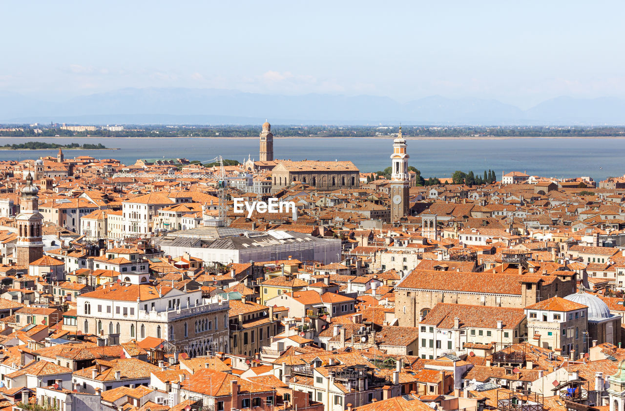 HIGH ANGLE VIEW OF TOWNSCAPE AGAINST SEA