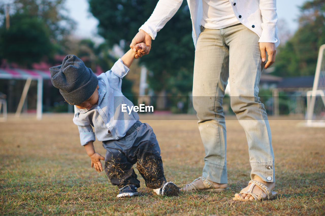 Low section of father and son on field