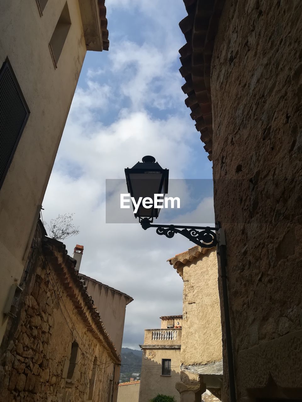 LOW ANGLE VIEW OF STREET LIGHT AGAINST BUILDINGS