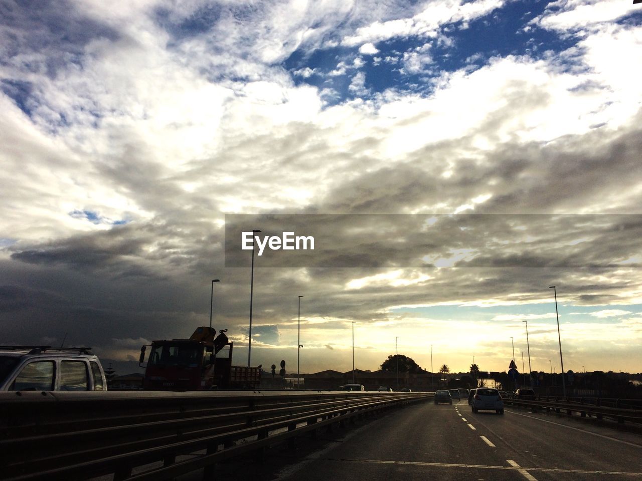 ROAD PASSING THROUGH DRAMATIC SKY AT SUNSET