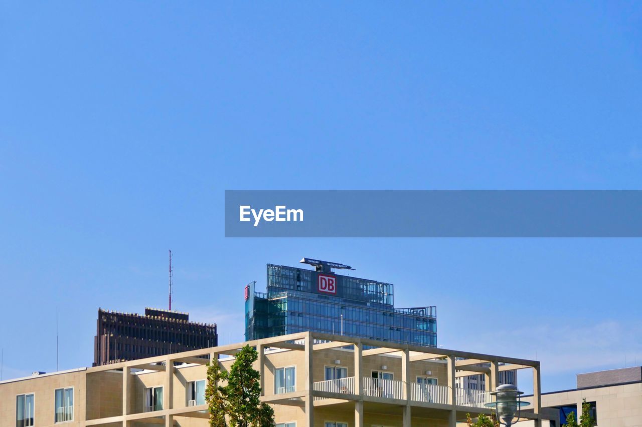 LOW ANGLE VIEW OF MODERN BUILDING AGAINST BLUE SKY