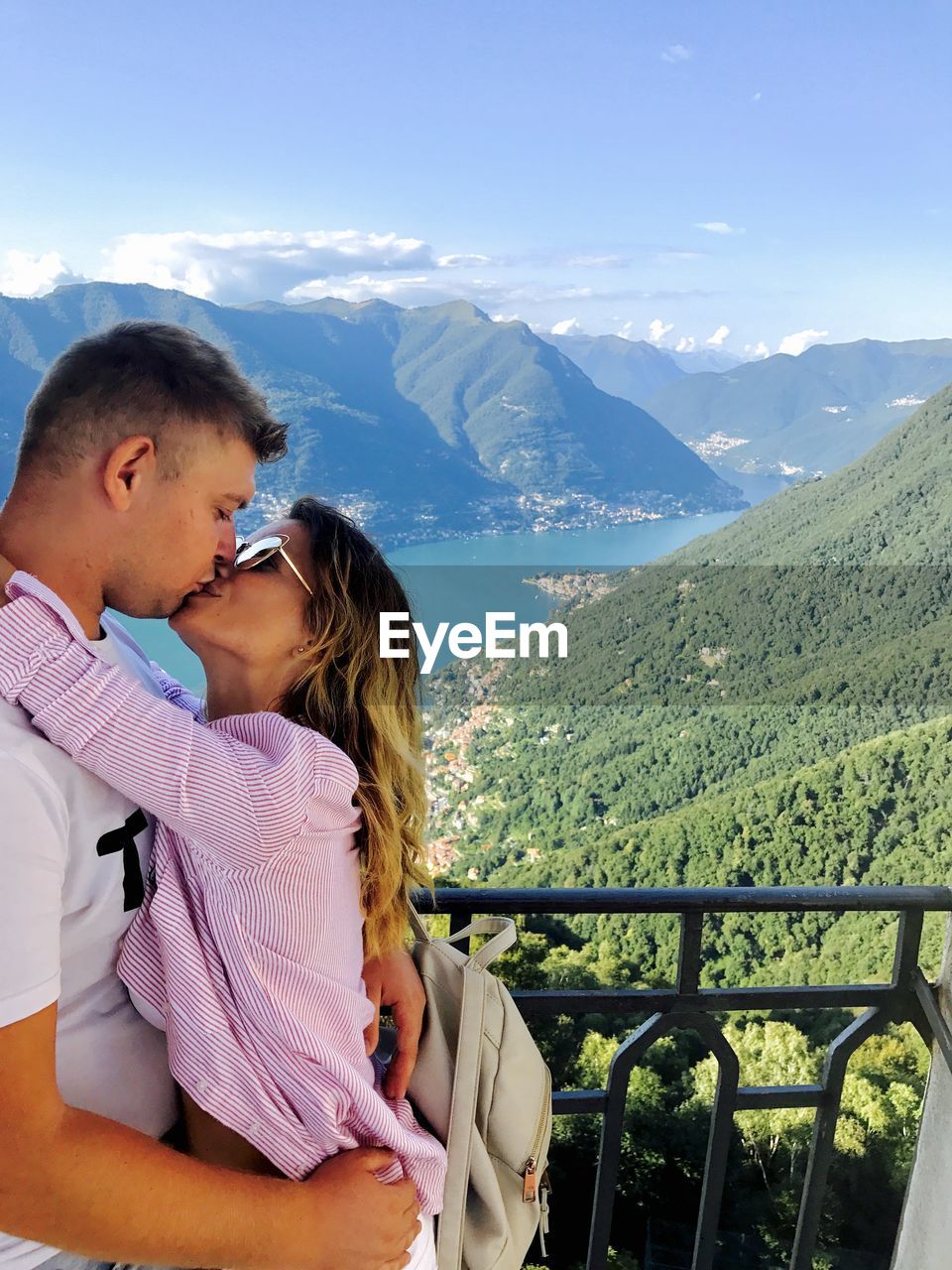 Couple kissing against mountains