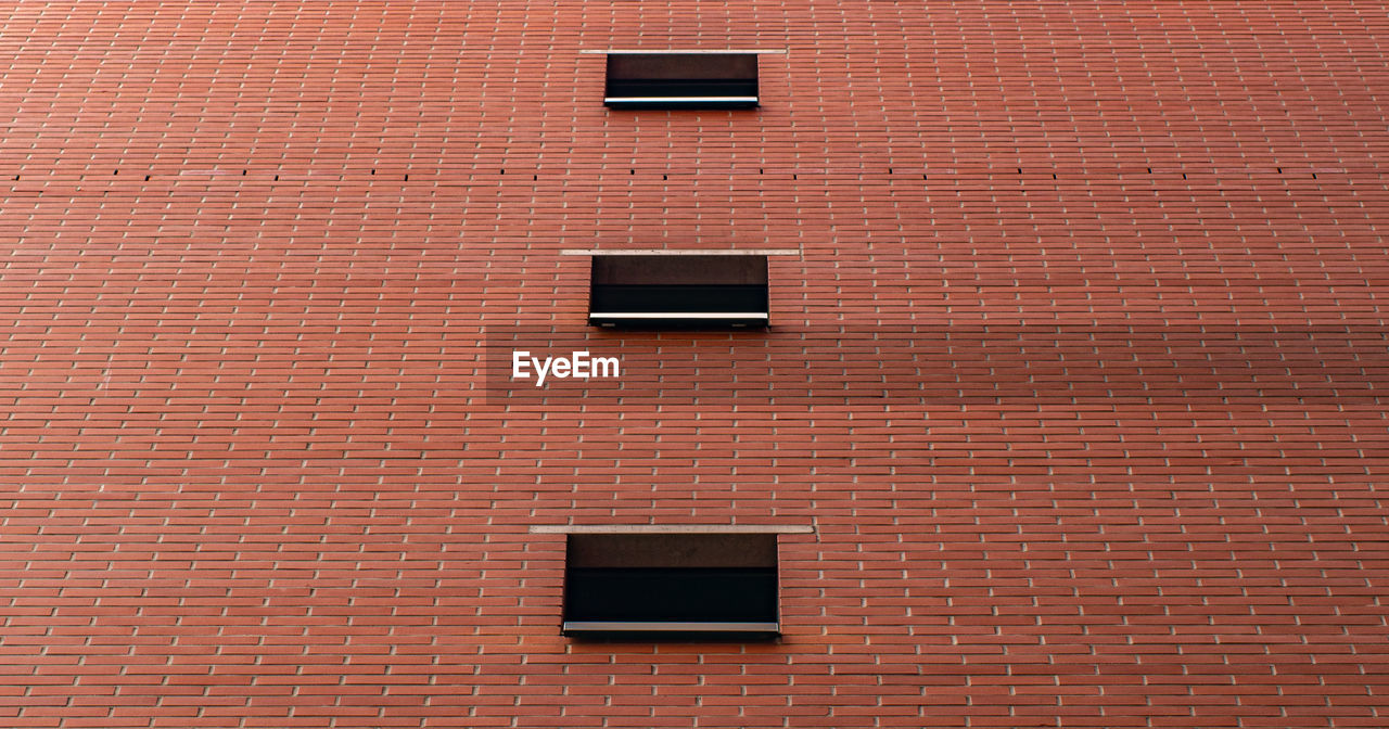 LOW ANGLE VIEW OF BRICK WALL ON WINDOW OF BUILDING