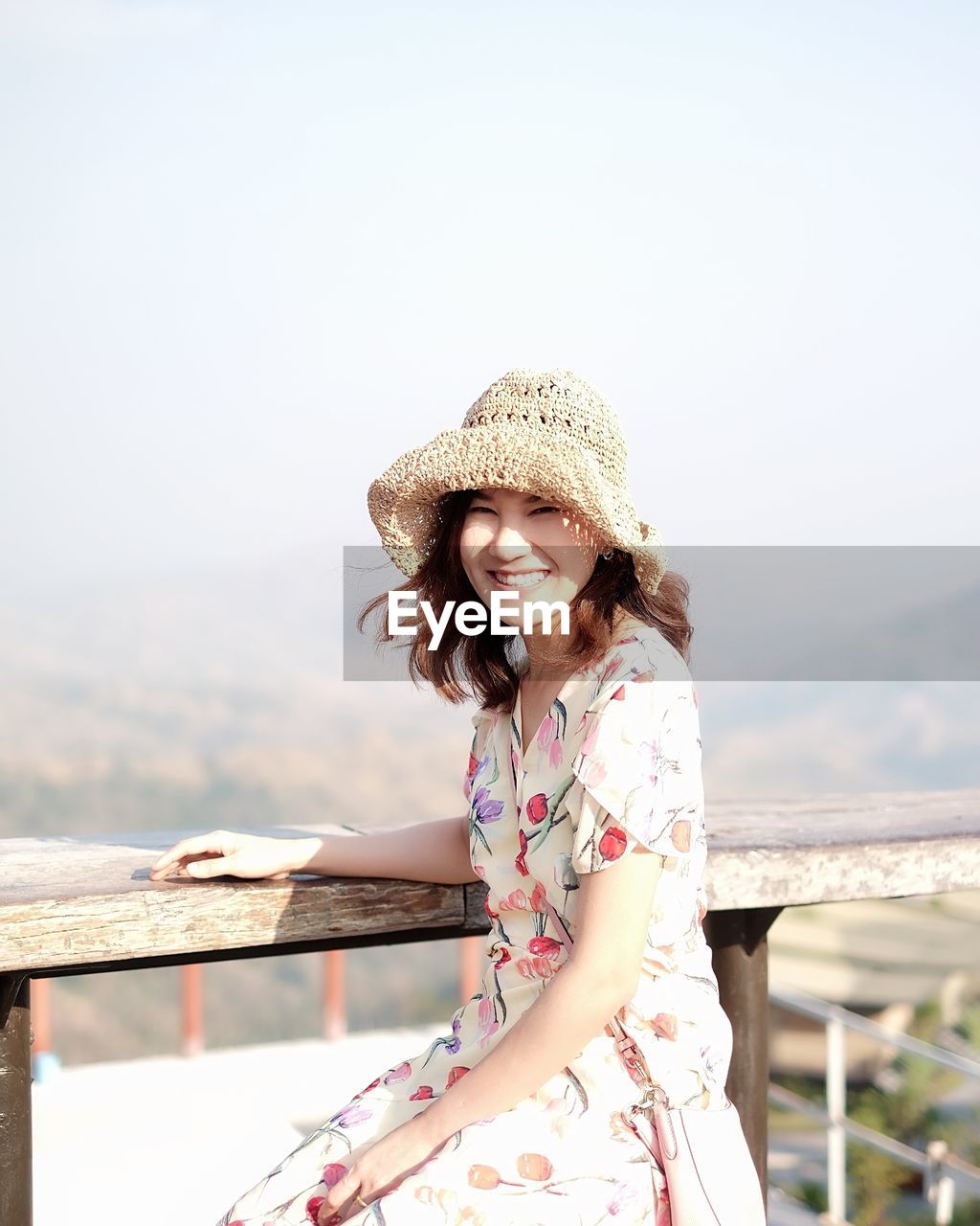 Woman wearing hat standing against sea