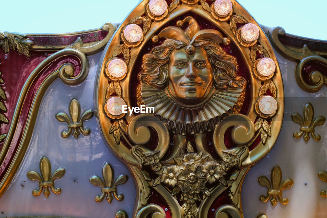 Detail on antique decoration of a carousel Carousel Ornate Gold Colored Day Close-up No People Gold Outdoors Sky Lamps Light Bulbs Joker Decoration Fleur De Lys Gold White Red Royalty Royal California Jacks Jack Santa Rosa USA