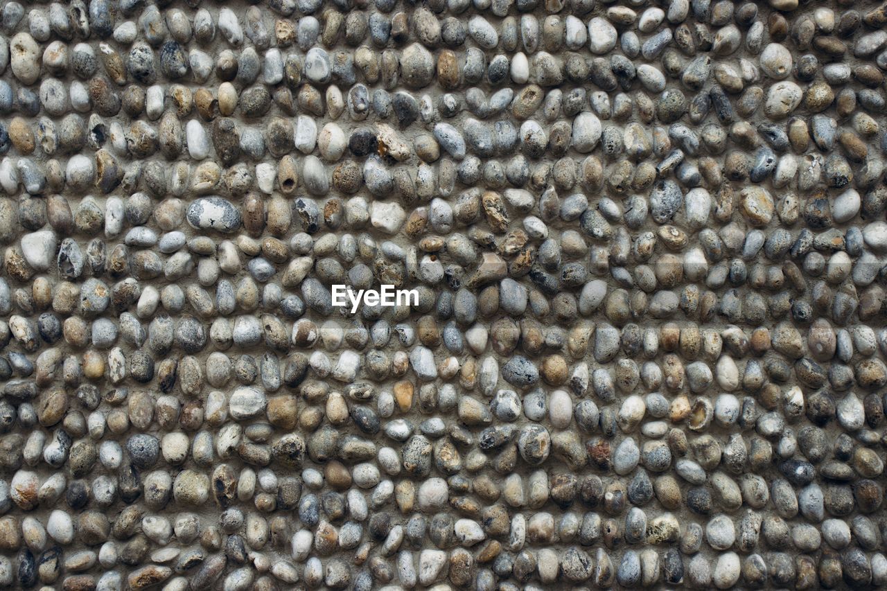 FULL FRAME SHOT OF PEBBLES ON ROCKS