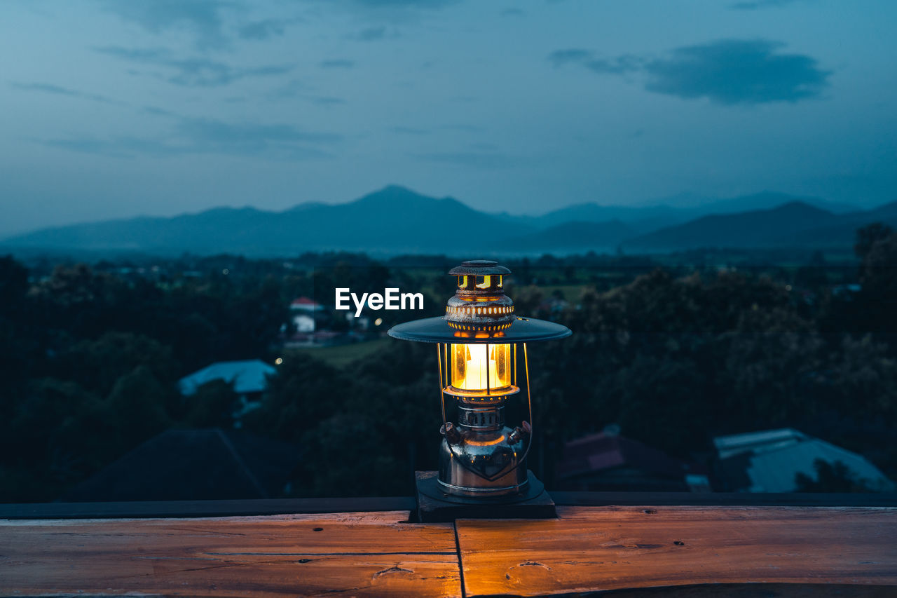 View of lantern on table against mountain