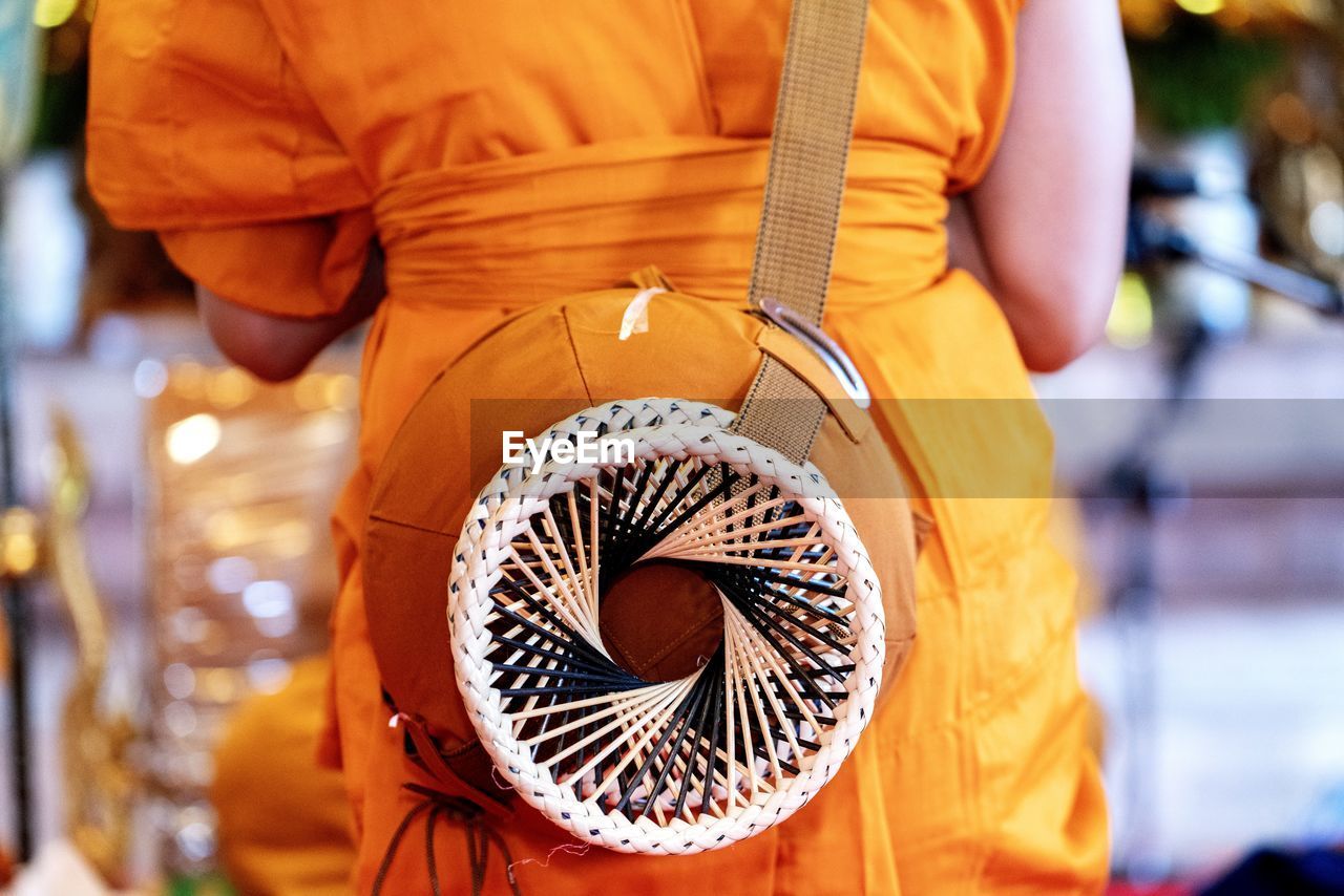 REAR VIEW OF MAN WORKING WITH ORANGE HAIR