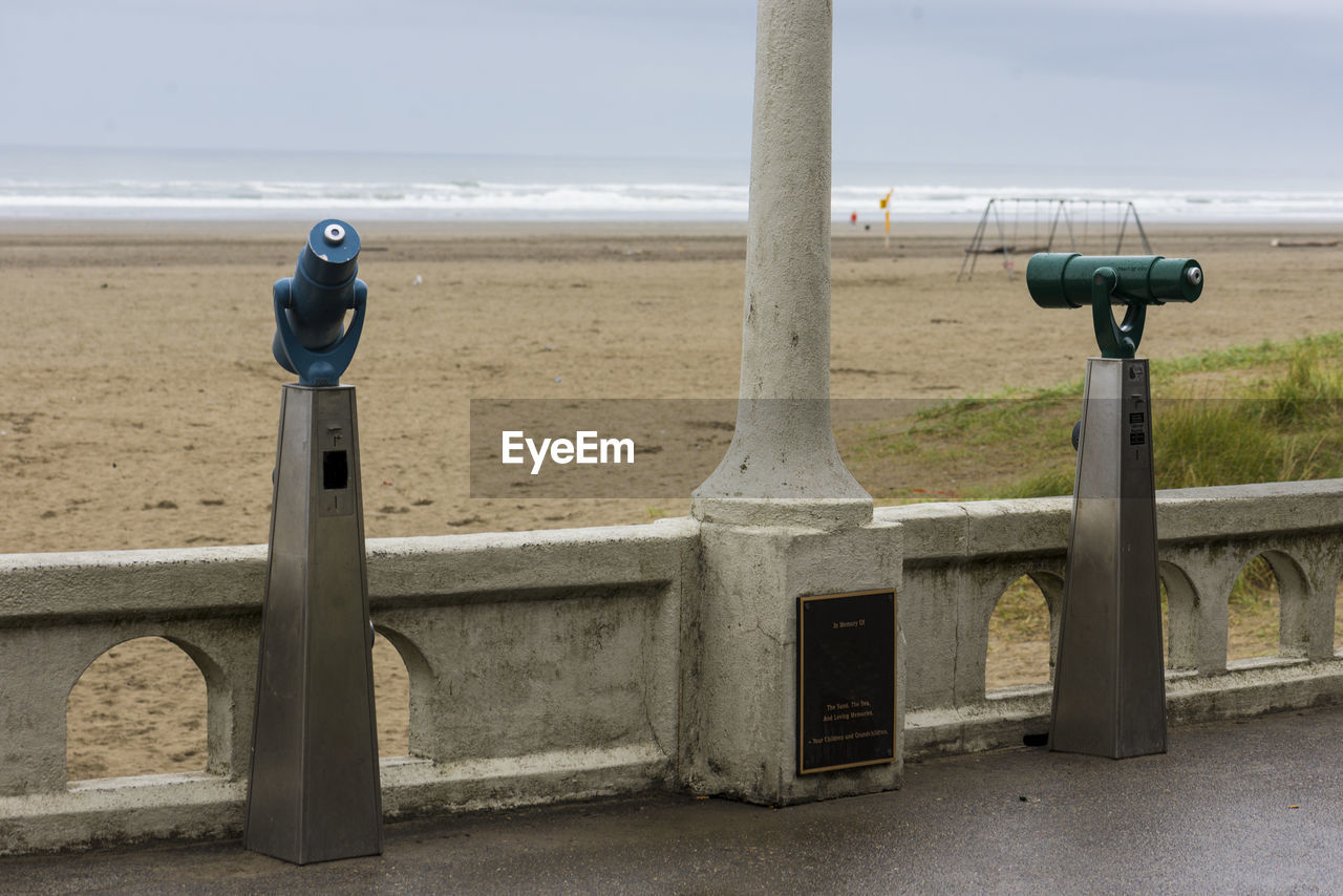 CLOSE-UP OF COIN-OPERATED BINOCULARS AGAINST SEA