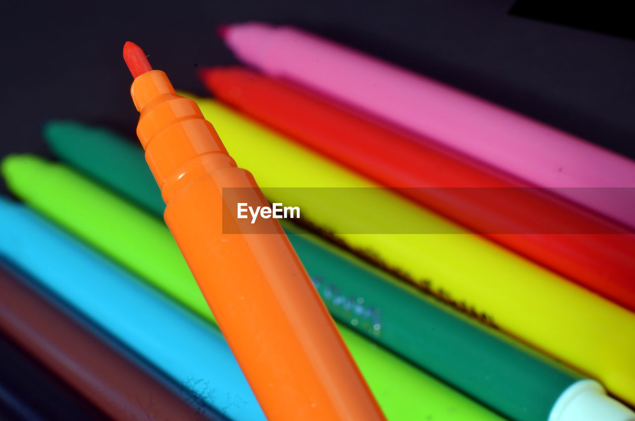 Close-up of multi colored felt tip pens against black background