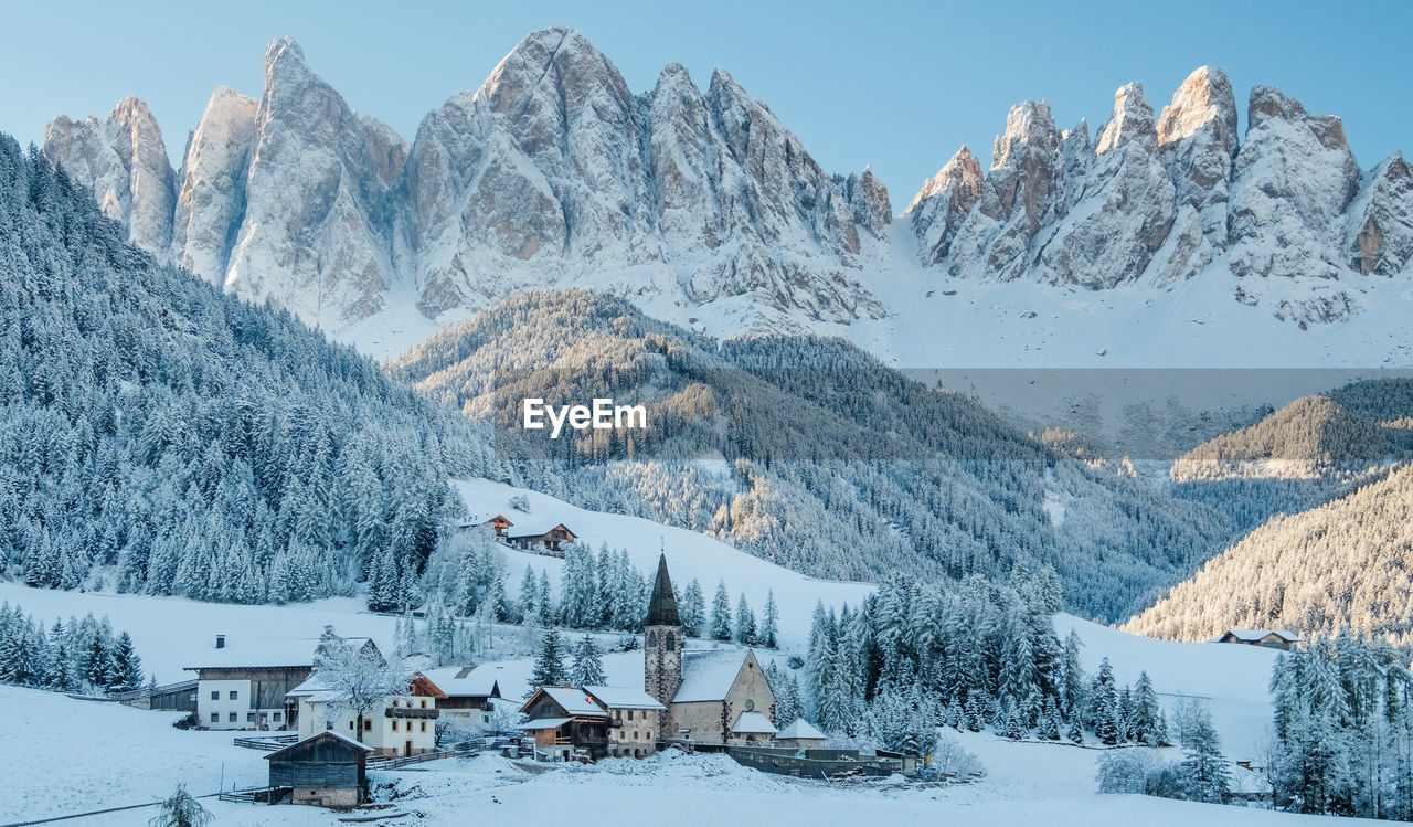 The small village val di funes covered in snow, with dolomites mountains, south tyrol, italy.