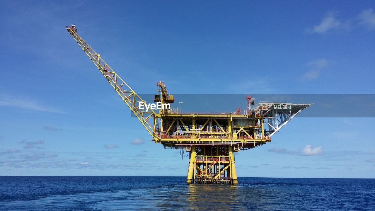 CRANES AT SEA AGAINST SKY