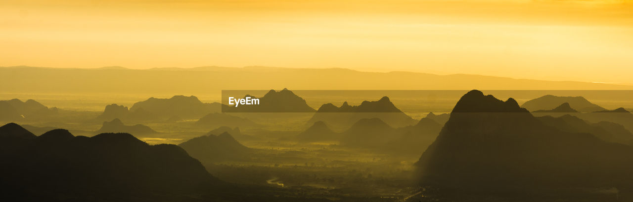 SCENIC VIEW OF SILHOUETTE MOUNTAINS DURING SUNSET