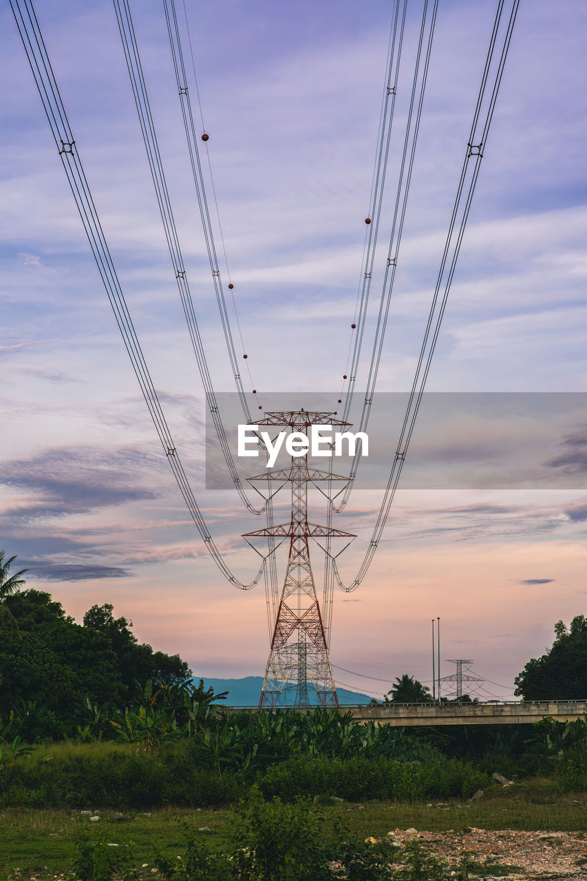 low angle view of electricity pylons against sky during sunset