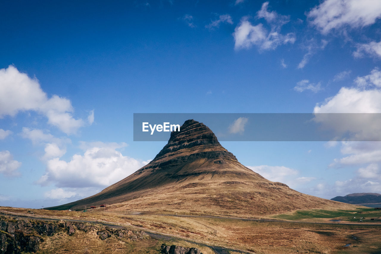 Low angle view of kirkjufell against blue sky