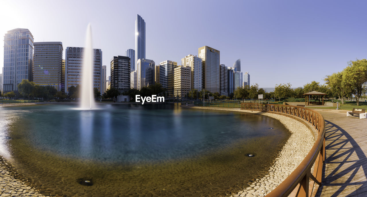 BUILDINGS BY SWIMMING POOL AGAINST SKY