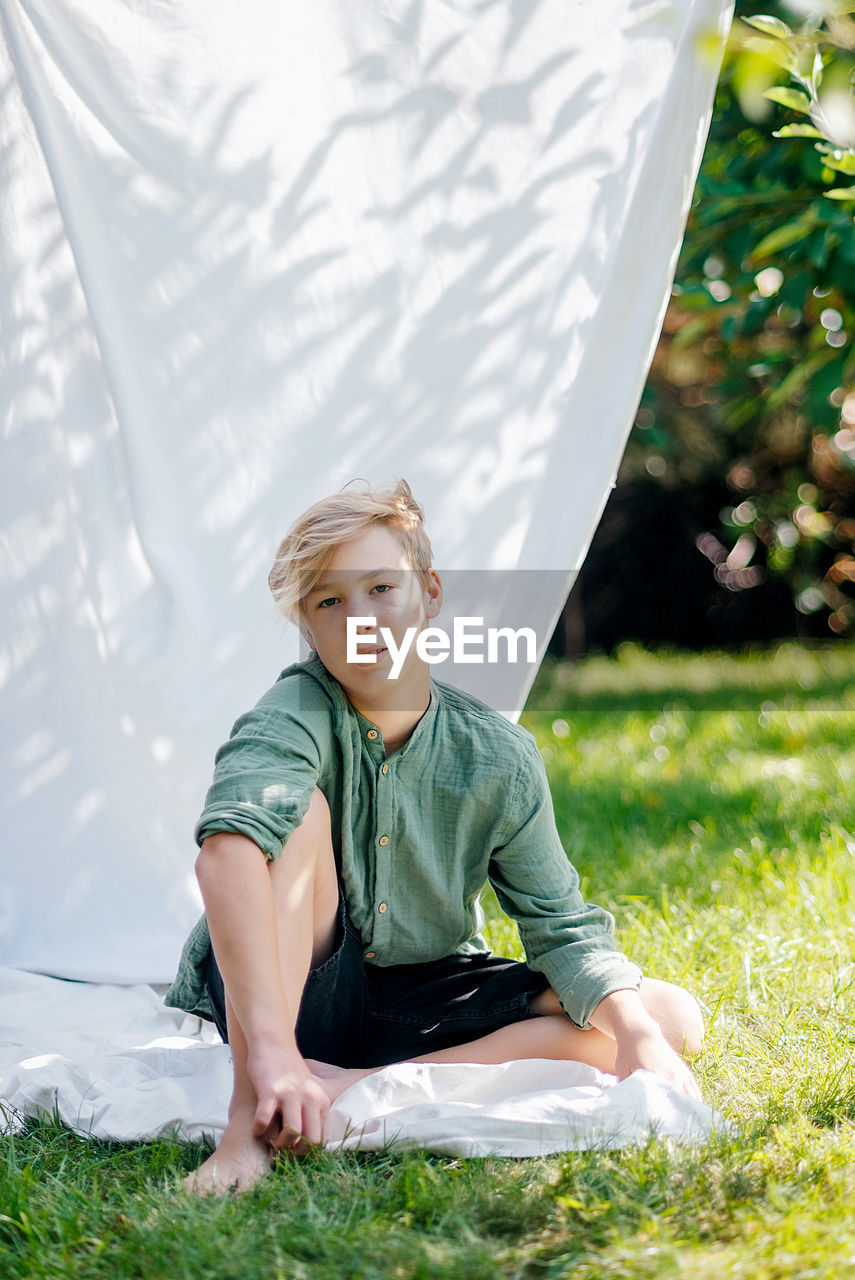 Portrait of young man sitting on tent