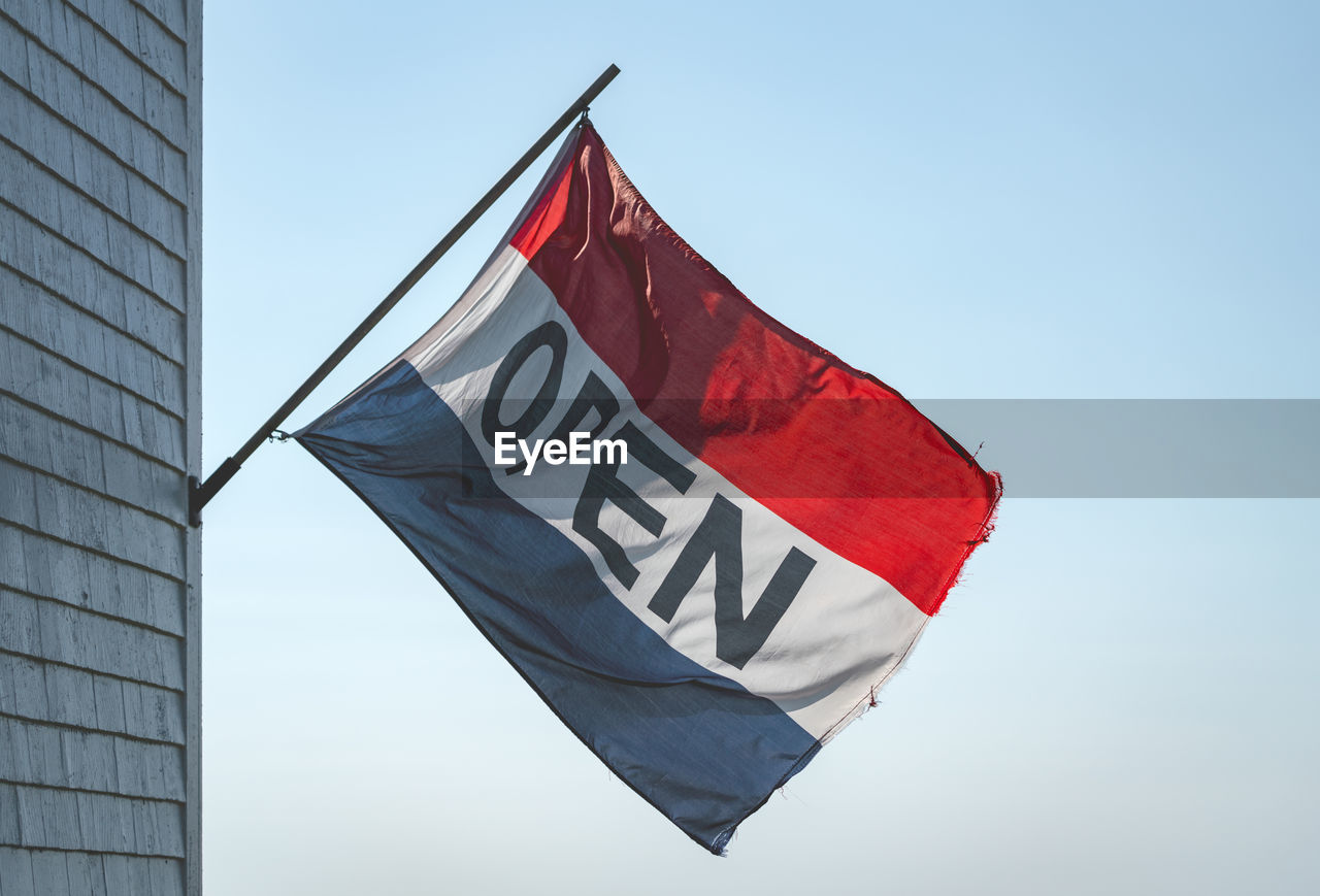 LOW ANGLE VIEW OF FLAG AGAINST BUILDINGS