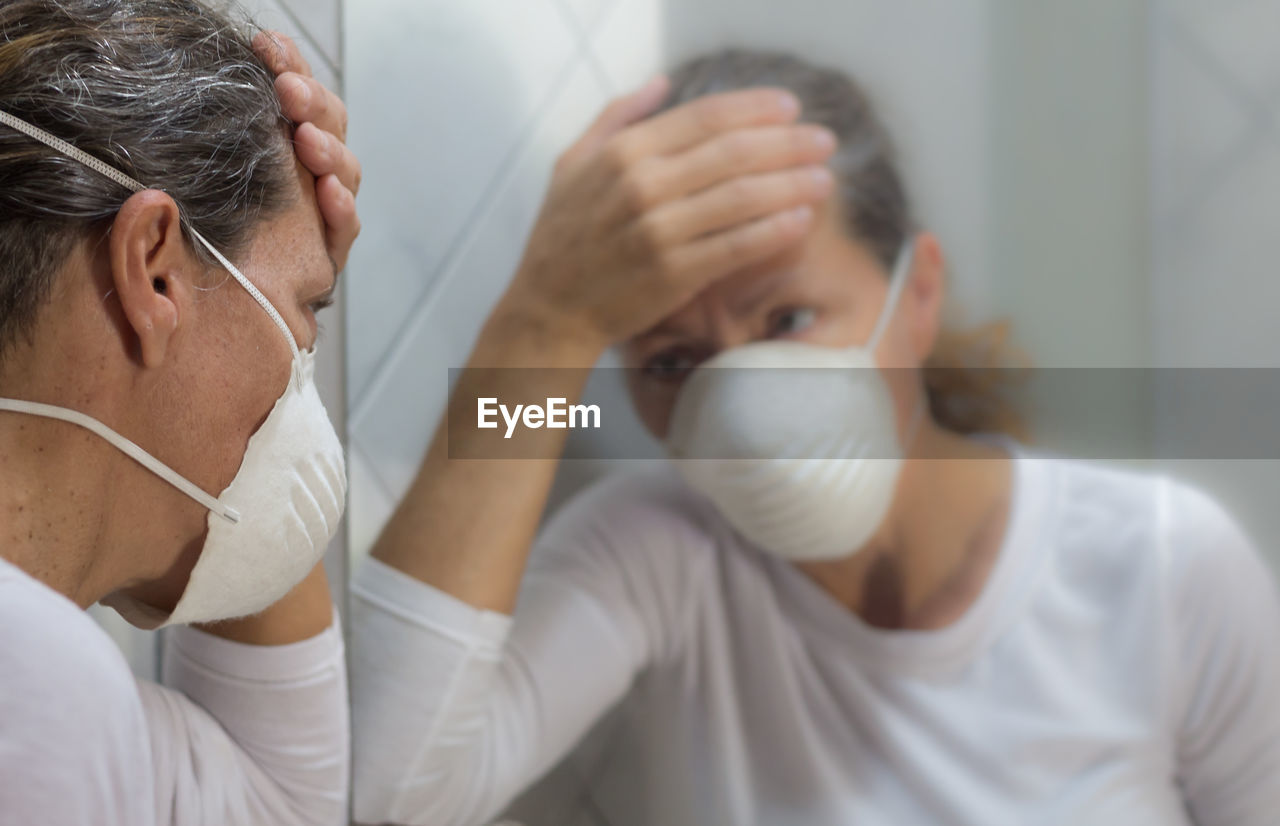 Adult woman with thermometer and chinstrap in prevention of influenza virus and coronavirus