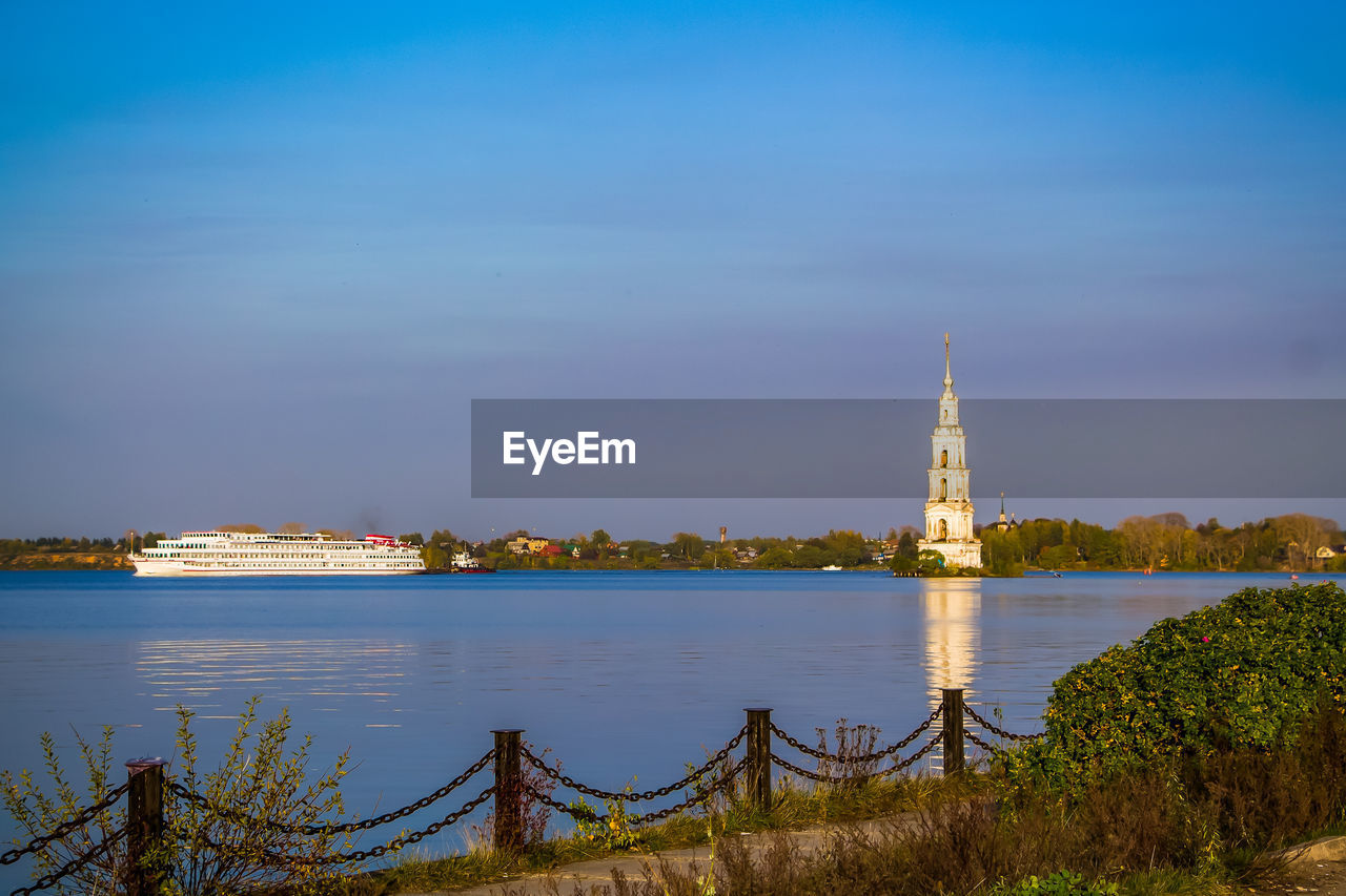 Beautiful christian church with golden domes among green trees.