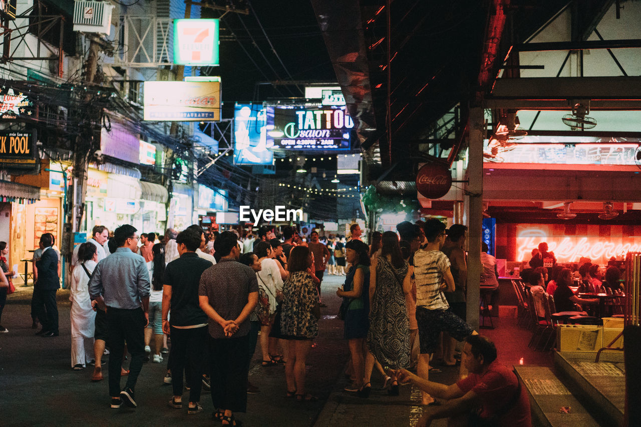 PEOPLE WALKING ON STREET AT NIGHT IN CITY