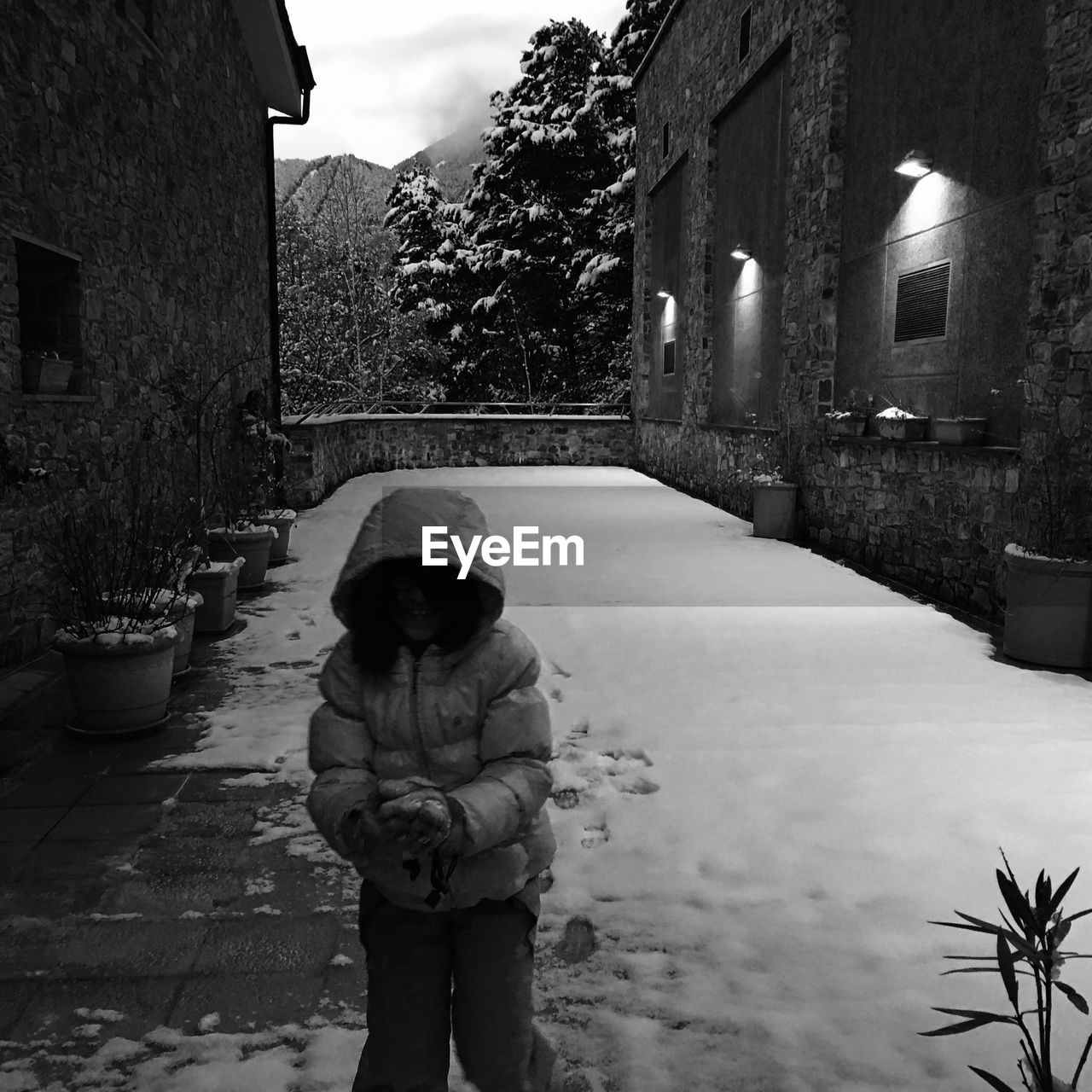 Girl walking on snowy footpath in city