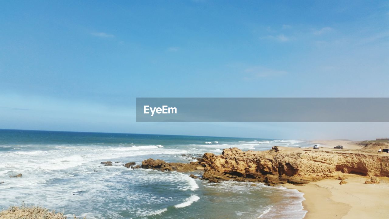 SCENIC VIEW OF ROCKS ON BEACH AGAINST SKY