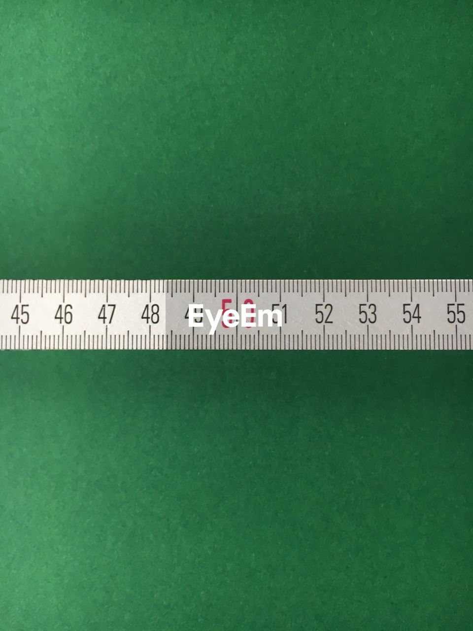 Close-up of tape measure against green background