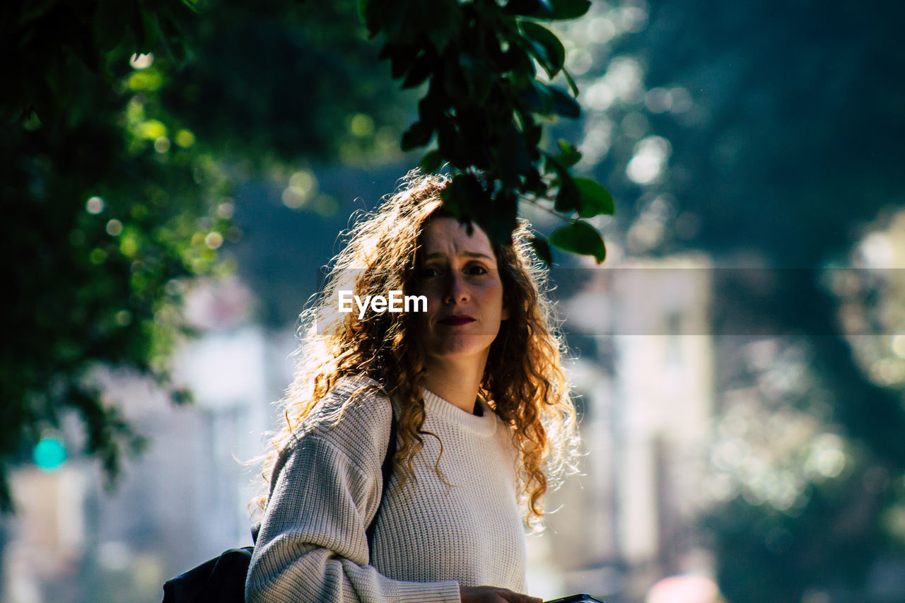 PORTRAIT OF BEAUTIFUL WOMAN AGAINST TREES