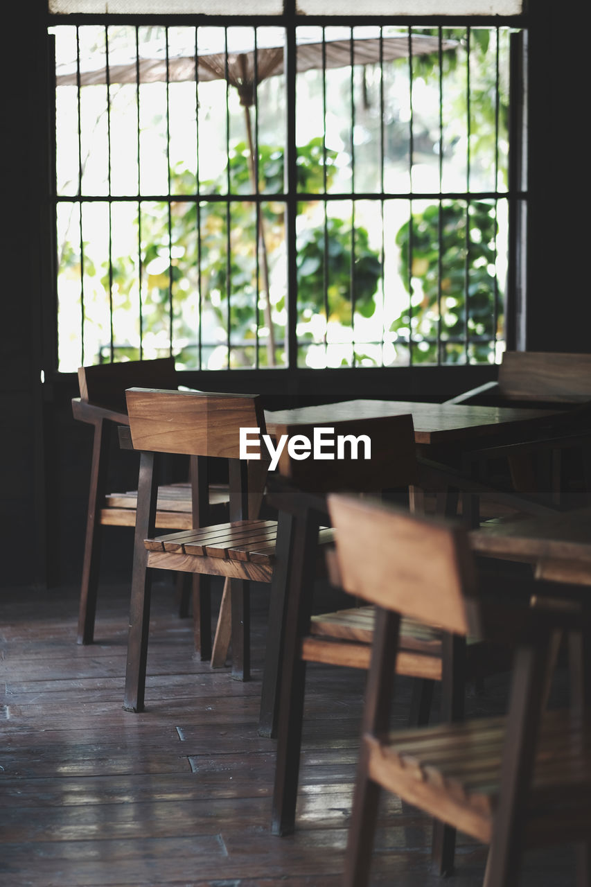 Empty chairs and table by window