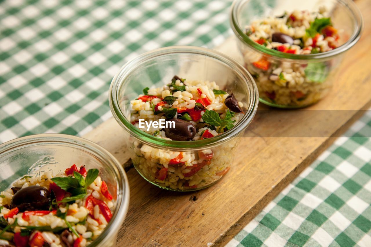 High angle view of rice and vegetables served in bowl on wood