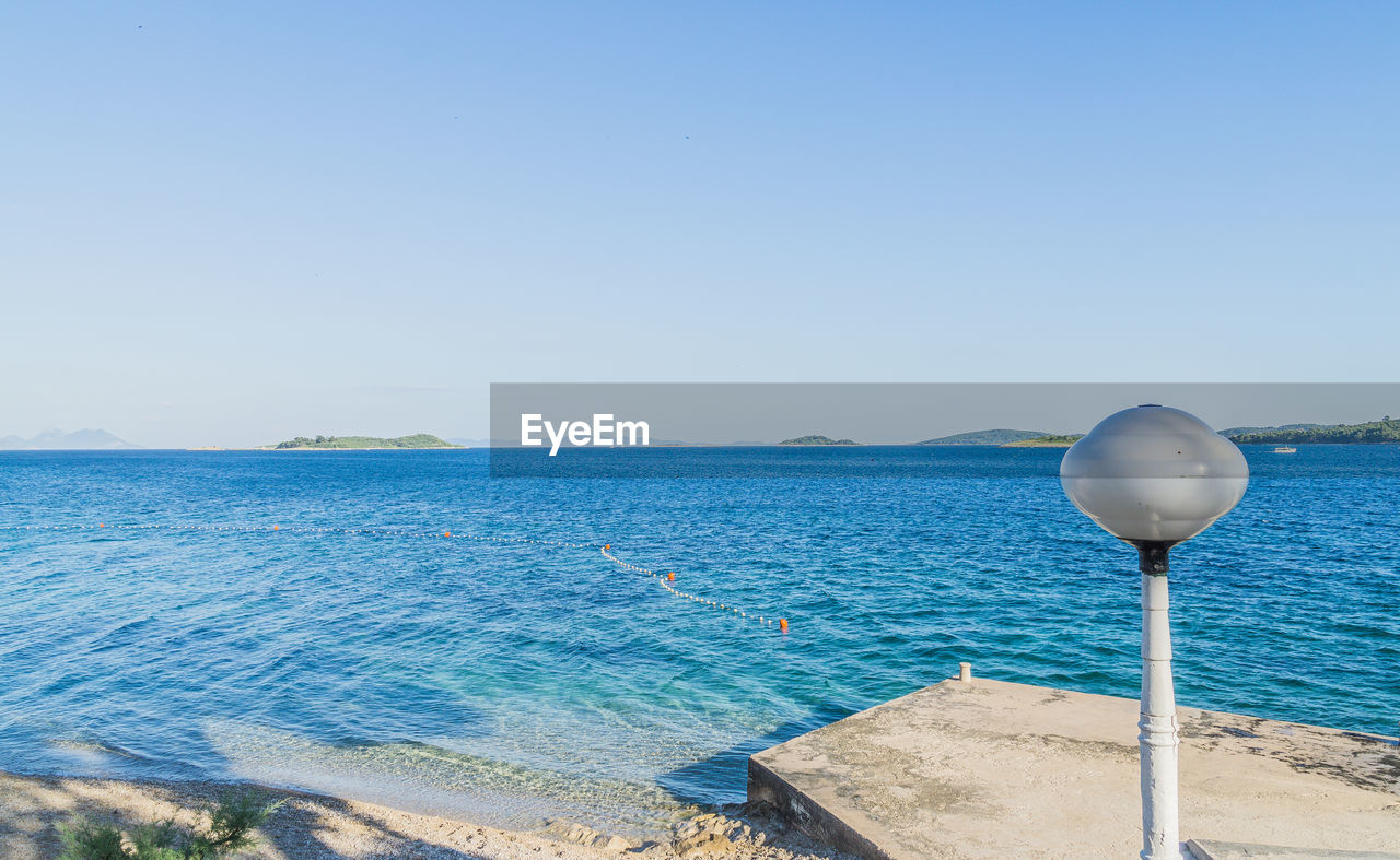 Scenic view of sea against clear blue sky