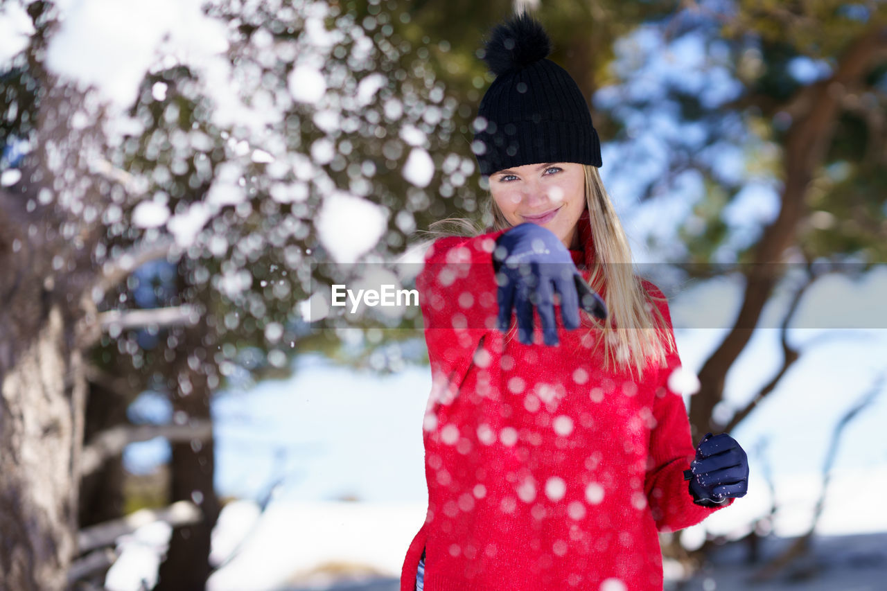 Rear view of woman on snow covered tree during winter