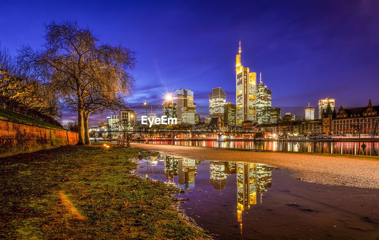 Illuminated buildings in city against sky at night