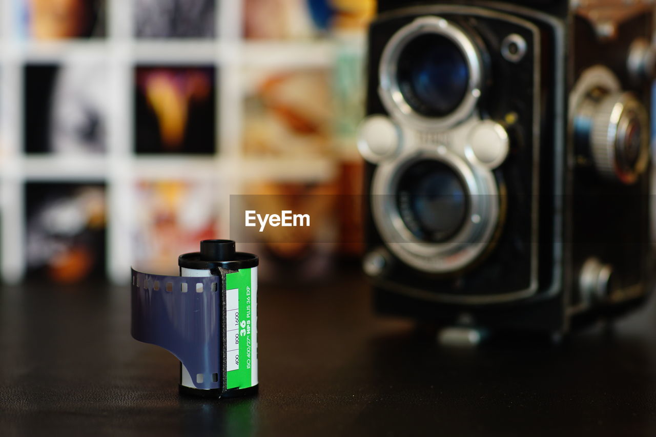 Close-up of roll film and vintage camera on black table