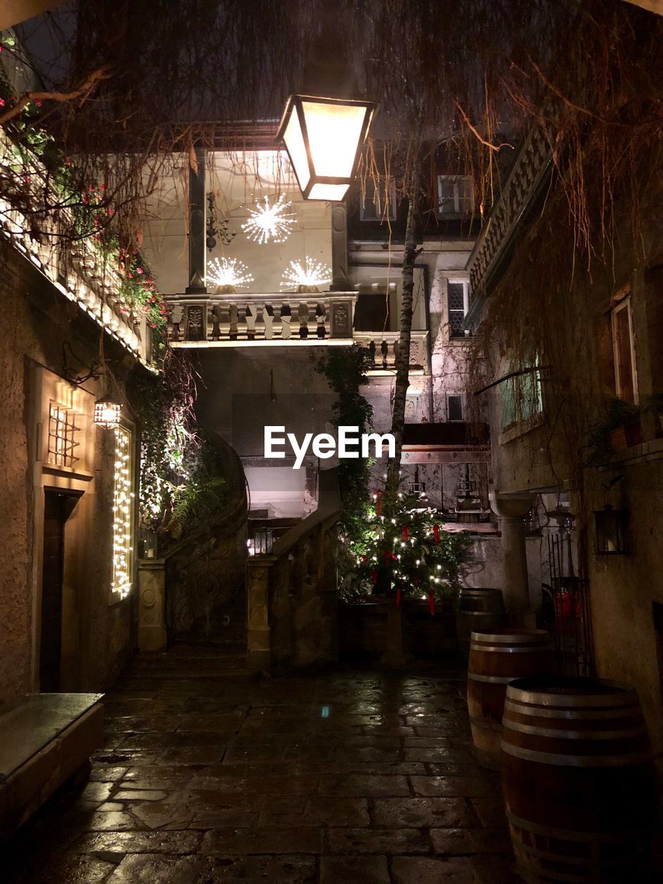 Illuminated alley amidst buildings in city at night