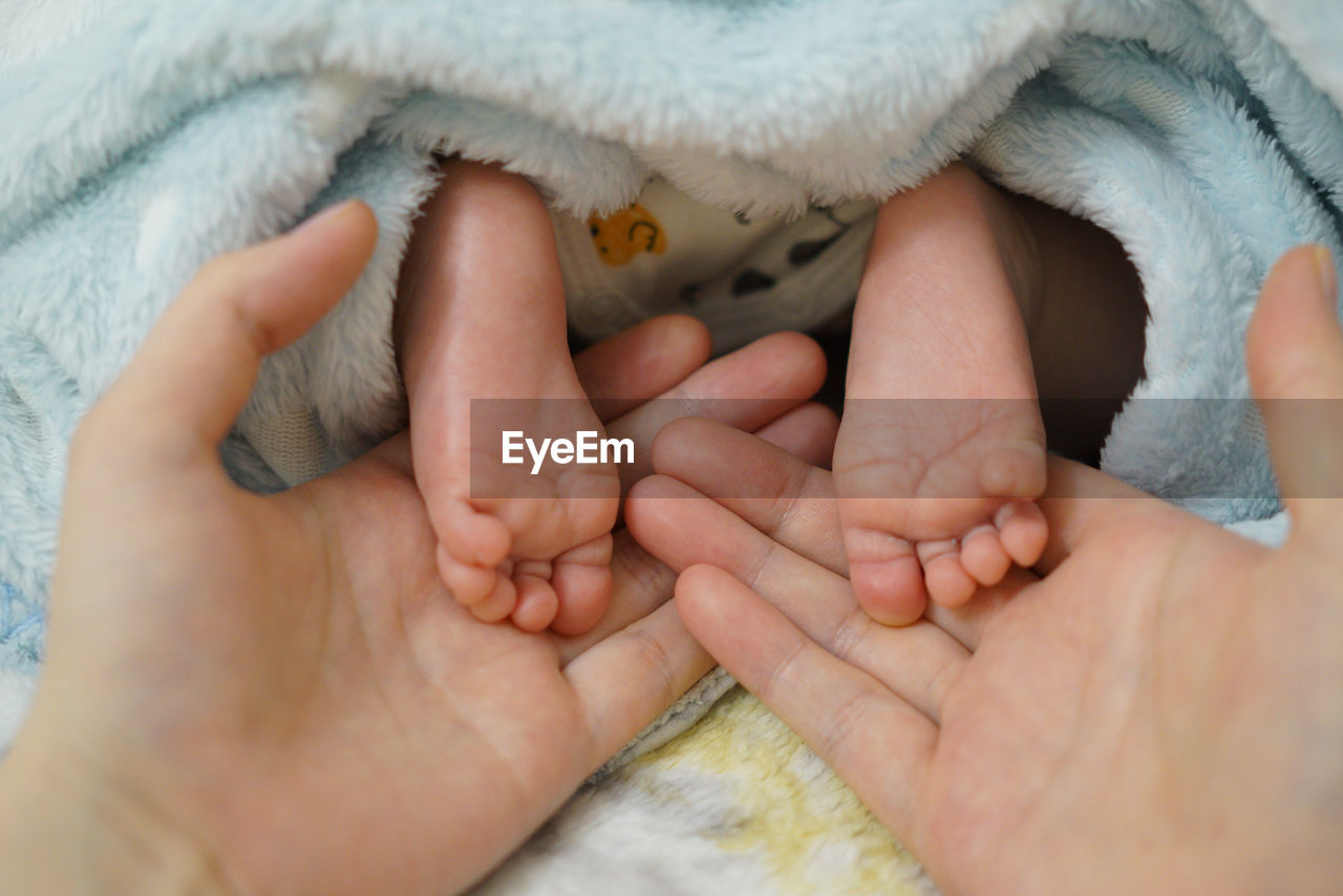 human leg, hand, baby, child, close-up, limb, newborn, childhood, skin, togetherness, adult, human foot, toddler, two people, beginnings, women, family, female, bonding, finger, care, love, emotion, indoors, positive emotion, relaxation, holding, cute, barefoot, innocence, parent, blanket, babyhood, person, lifestyles, men, human limb