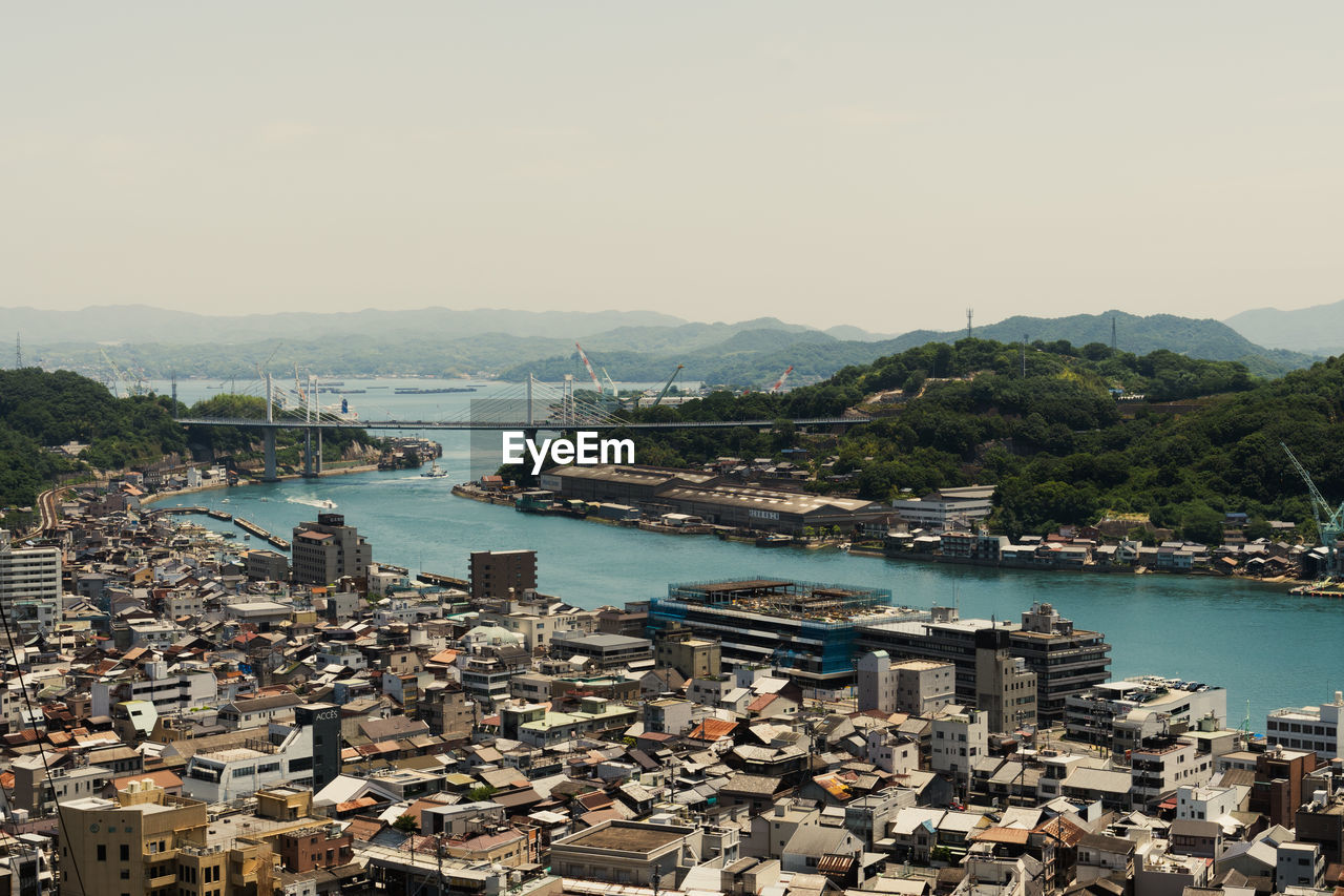 High angle view of bay and buildings against clear sky