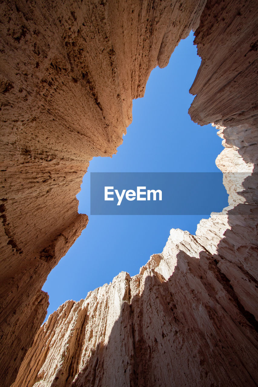 Low angle view of rock formation against clear blue sky. slot canyon 