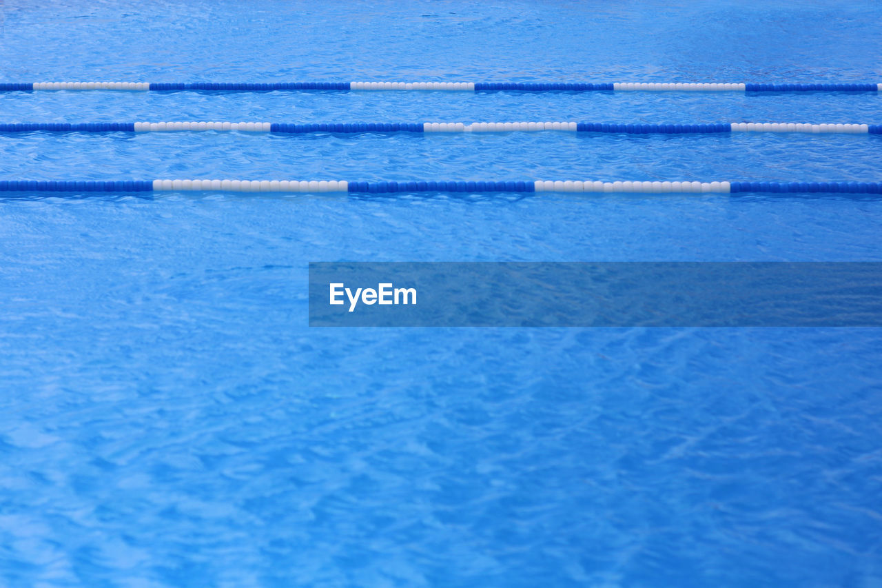 CLOSE-UP OF SWIMMING POOL AGAINST BLUE WATER