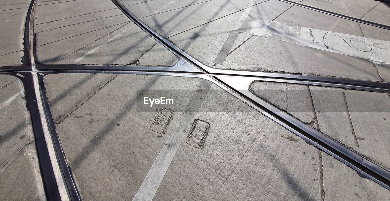 line, high angle view, no people, pattern, day, floor, iron, sunlight, full frame, outdoors, road surface, wheel, wing, backgrounds, nature, tarmac, tire