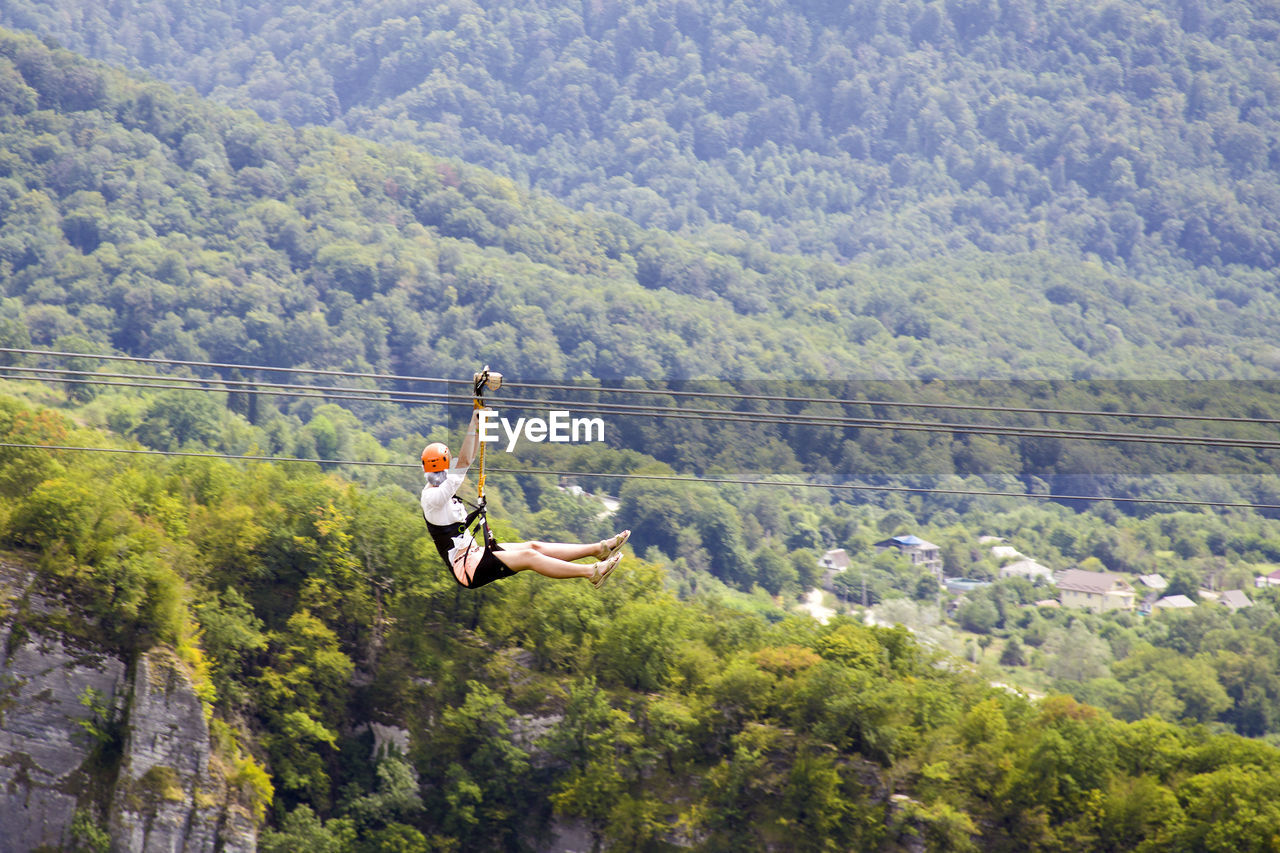 MAN AND ROPE HANGING ON MOUNTAIN