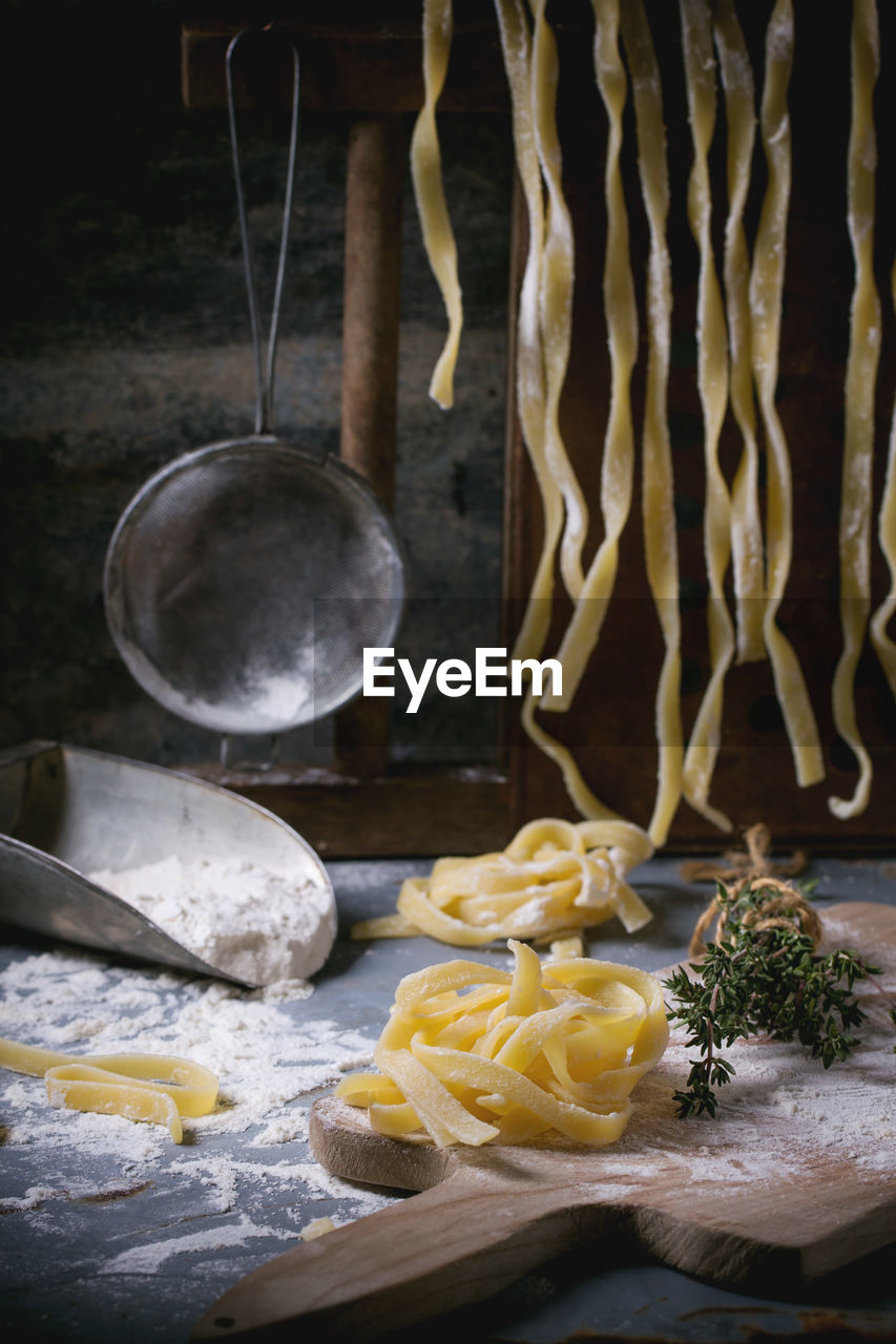 Raw pasta by flour on table