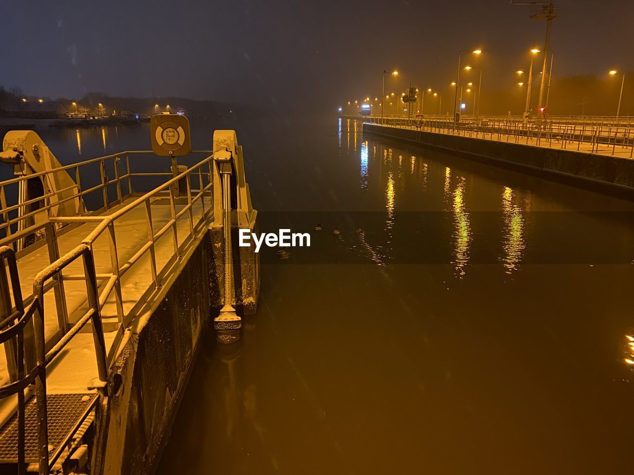 BRIDGE OVER RIVER AGAINST SKY AT NIGHT