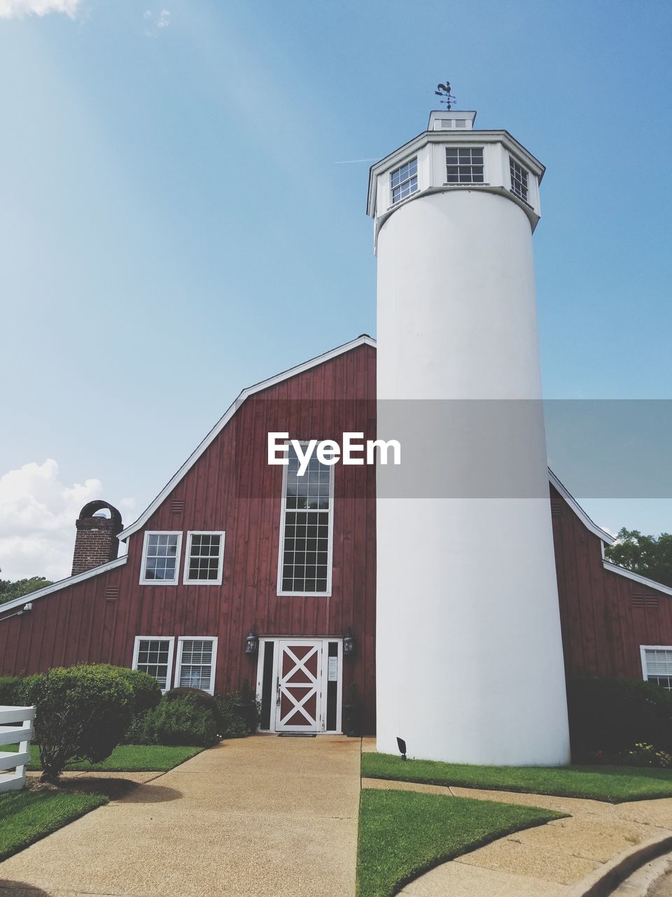 Low angle view of lighthouse by building against sky