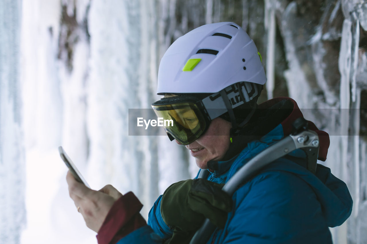 Female ice climber using cell phone